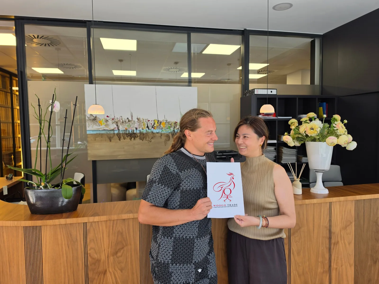 The two Woogo Trade founders holding the Woogo rooster logo